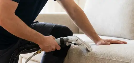 Professional upholstery cleaner deep-cleaning a fabric sofa with a handheld extraction tool, San Francisco, CA.